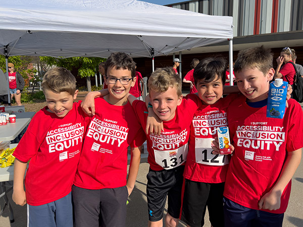 A group of boys pose in their red shirts.